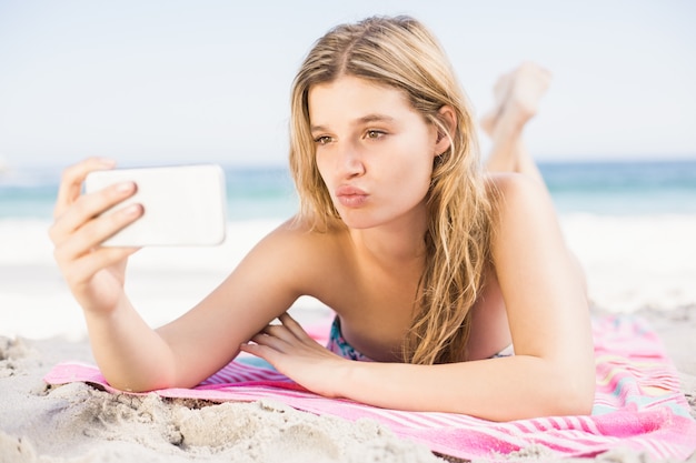 Jeune femme prenant un selfie sur téléphone mobile