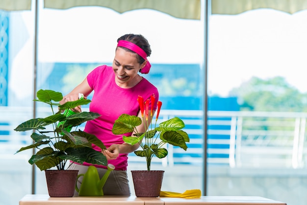 Jeune femme prenant soin des plantes de la maison