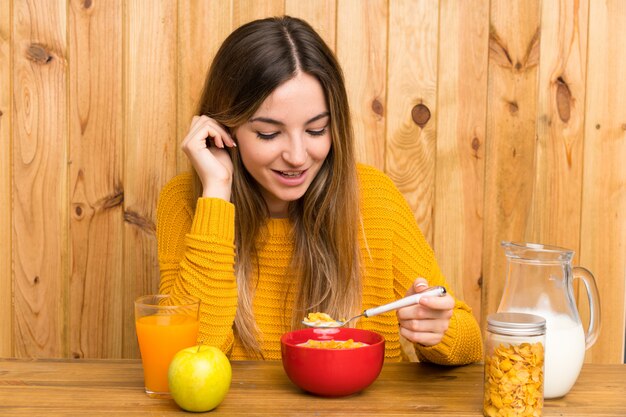 Jeune femme prenant son petit déjeuner dans une cuisine