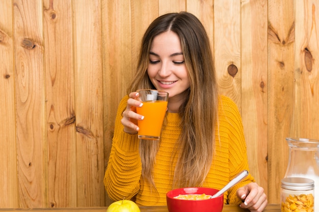 Jeune femme prenant son petit déjeuner dans une cuisine