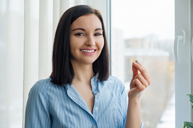 Jeune femme prenant vitamine