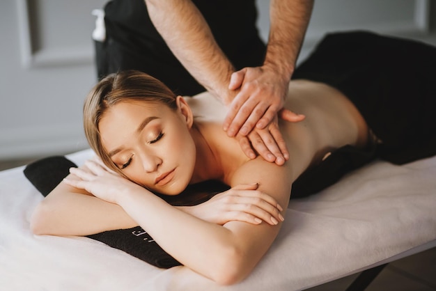 Une jeune femme prend un massage dans un salon SPA