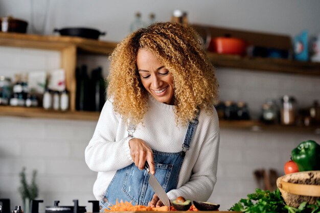 Photo une jeune femme prépare la nourriture à la maison.