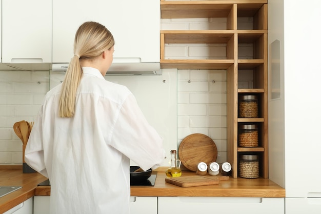Une jeune femme prépare le petit déjeuner dans la cuisine