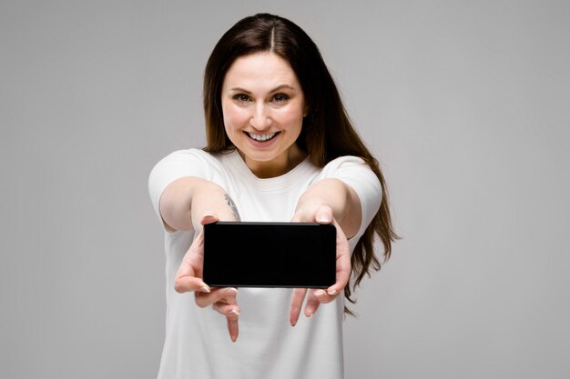 Jeune femme présentant un téléphone