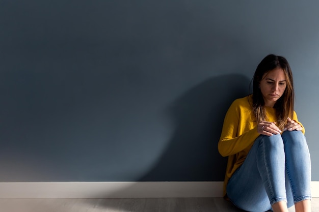 Jeune femme avec un problème mental assis sur le sol