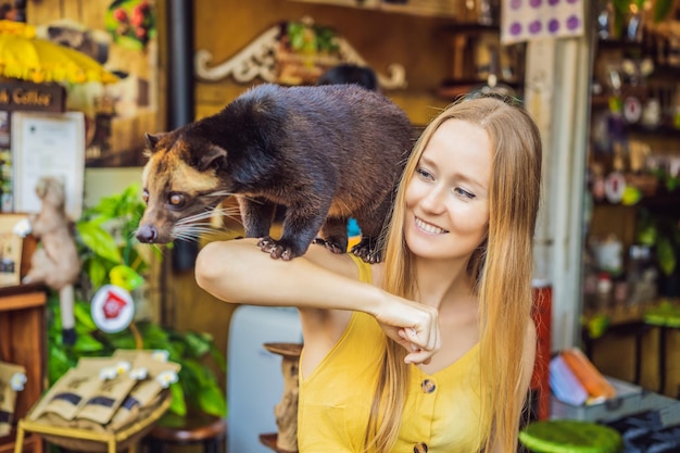 Photo jeune femme avec le producteur de café musang kopi luwak l'île de bali