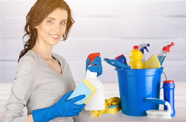 Jeune femme avec des produits de nettoyage sur fond flou