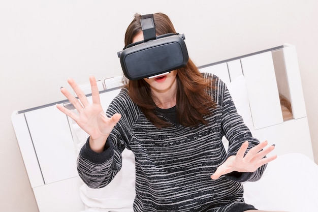 Jeune femme profiter avec des lunettes de réalité virtuelle à la maison