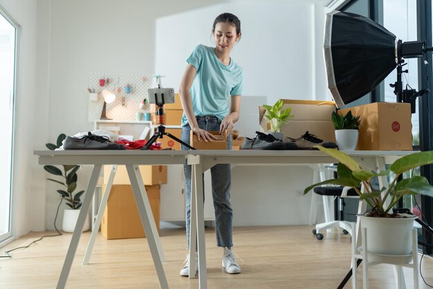 Une jeune femme propriétaire d'une petite entreprise de commerce électronique emballe des articles dans la boîte aux lettres