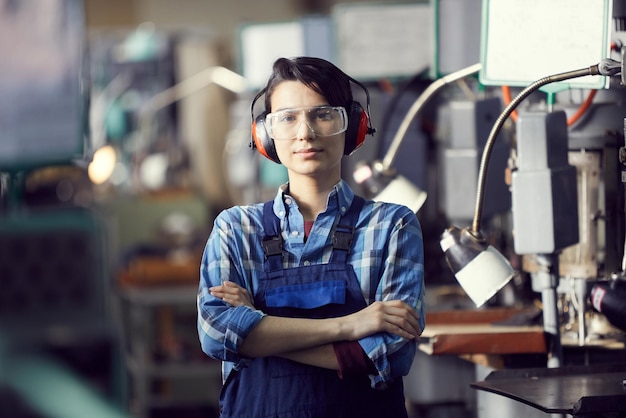 Jeune femme en protège-oreilles à l'usine