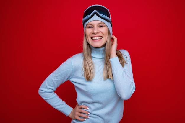 Une jeune femme en pull et lunettes de ski