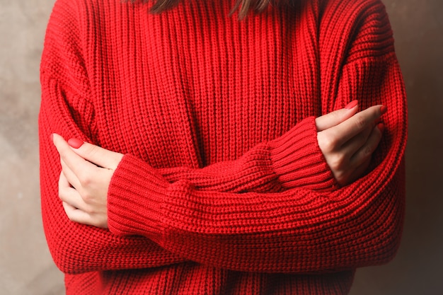 Jeune femme en pull rouge chaud, gros plan. Espace pour le texte