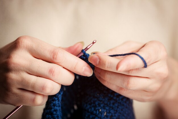 Jeune femme en pull à tricoter avec crochet