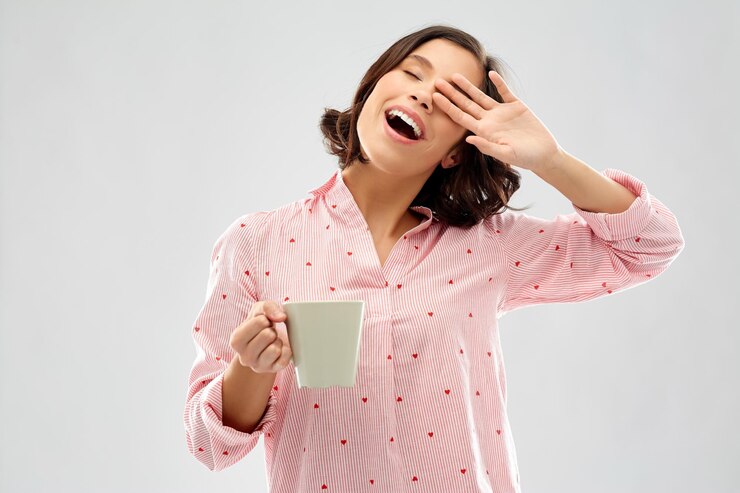 Photo une jeune femme en pyjama avec du café.