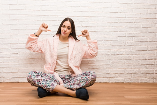 Jeune femme en pyjama pointant le doigt, exemple à suivre