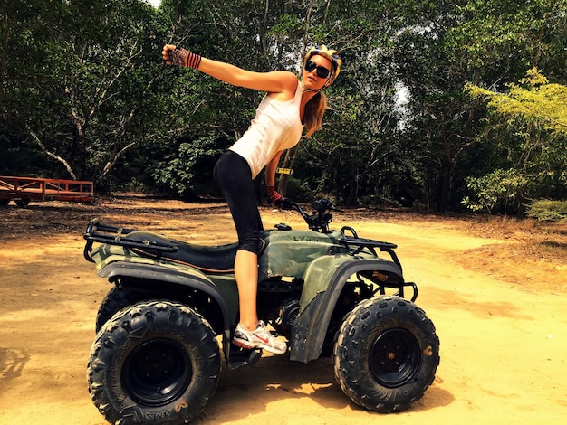 Photo jeune femme en quad dans la forêt