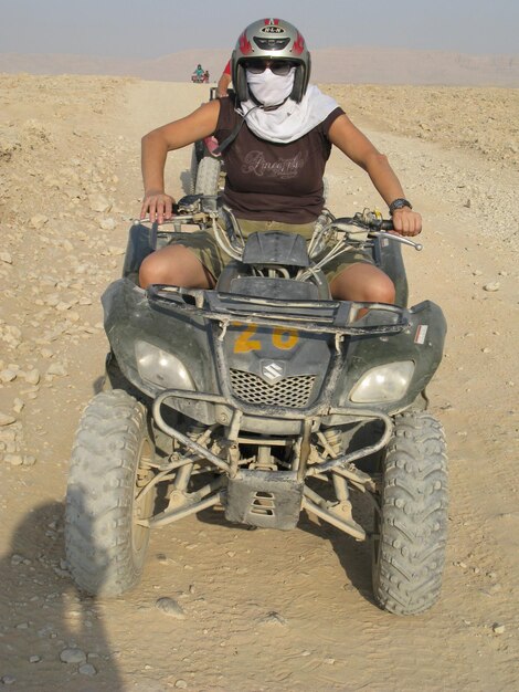 Photo une jeune femme sur un quad sur une route de terre