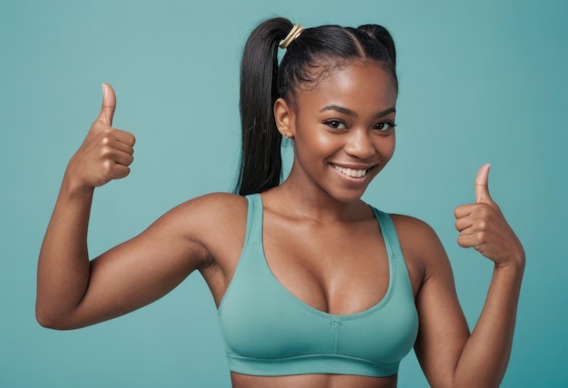 Une jeune femme avec des queues dans un soutien-gorge de sport donne un pouce enthousiaste son sourire radieux et