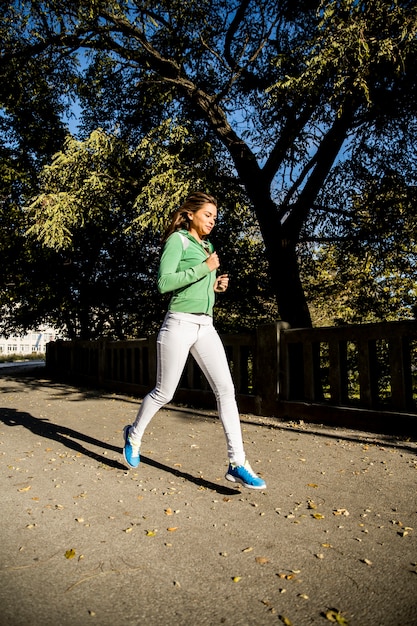 Photo jeune femme qui court dans le parc