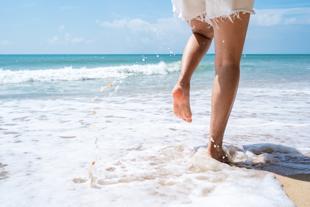 Jeune femme qui court sur la plage tropicale en journée ensoleillée