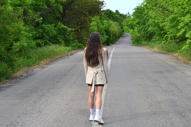 une jeune femme qui marche sur la route