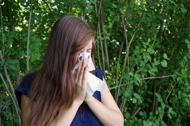 Une jeune femme qui souffle le nez.