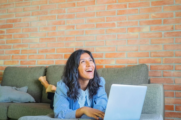 Photo une jeune femme qui utilise un ordinateur à la maison