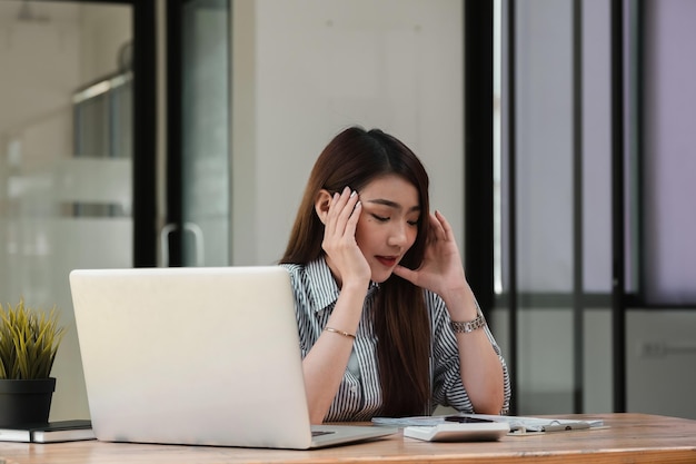 Une jeune femme qui utilise son téléphone alors qu'elle est assise sur la table.