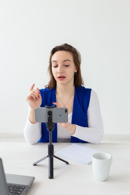 Photo une jeune femme qui utilise un téléphone portable sur la table.