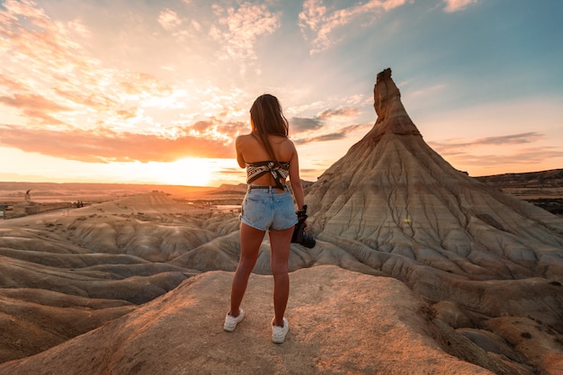 Jeune femme de race blanche avec un appareil photo en face de la formation Castildetierra au désert des Bardenas Reales, Navarre, Pays Basque.