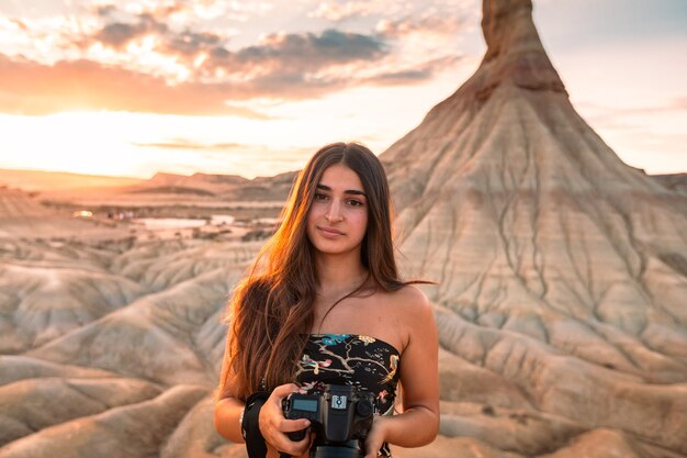 Jeune femme de race blanche avec un appareil photo en face de la formation Castildetierra au désert des Bardenas Reales, Navarre, Pays Basque.