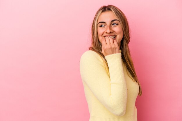 Jeune femme de race blanche blonde isolée sur un mur rose détendu penser à quelque chose en regardant un espace de copie