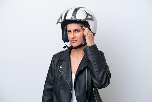 Jeune femme de race blanche avec un casque de moto isolé sur fond blanc ayant des doutes