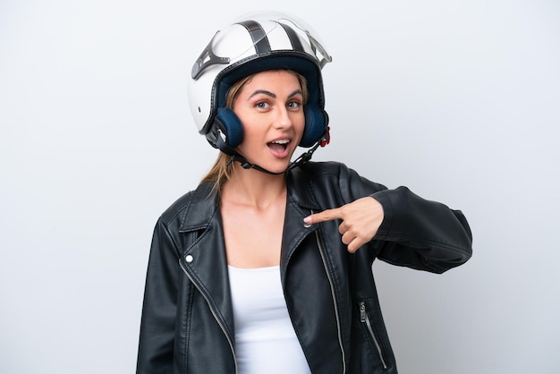 Jeune femme de race blanche avec un casque de moto isolé sur fond blanc avec une expression faciale surprise