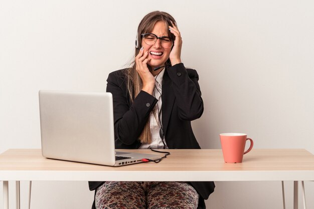 Jeune femme de race blanche faisant du télétravail isolé sur fond blanc pleurnichant et pleurant de manière inconsolable.