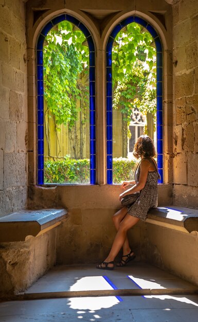 Une jeune femme de race blanche faisant du tourisme rural dans une ville médiévale et son beau château