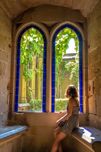 Une jeune femme de race blanche faisant du tourisme rural dans une ville médiévale et son beau château