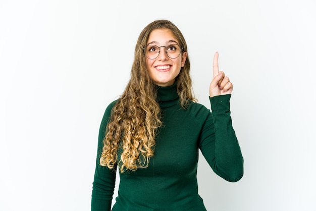 Jeune femme de race blanche indique avec les deux doigts avant vers le haut montrant un espace vide.