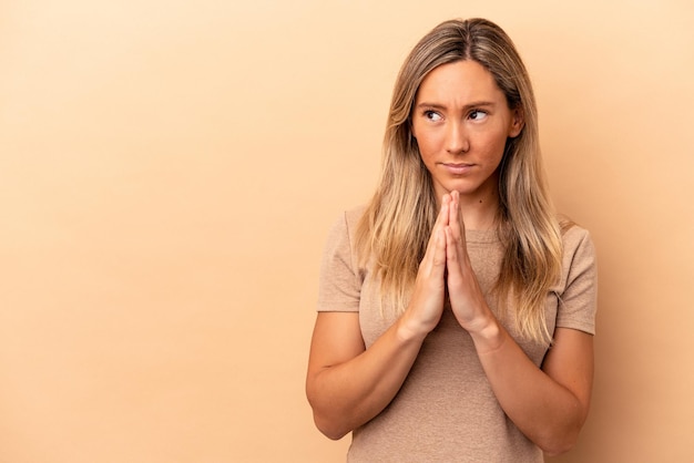 Jeune femme de race blanche isolée sur fond beige, élaboration d'un plan en tête, mise en place d'une idée.