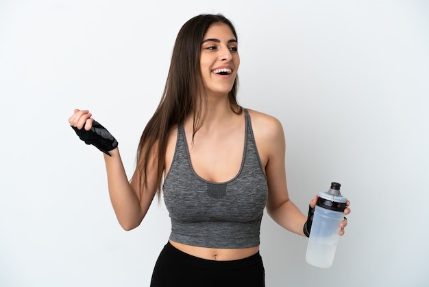 Jeune femme de race blanche isolée sur fond blanc avec une bouteille d'eau de sport