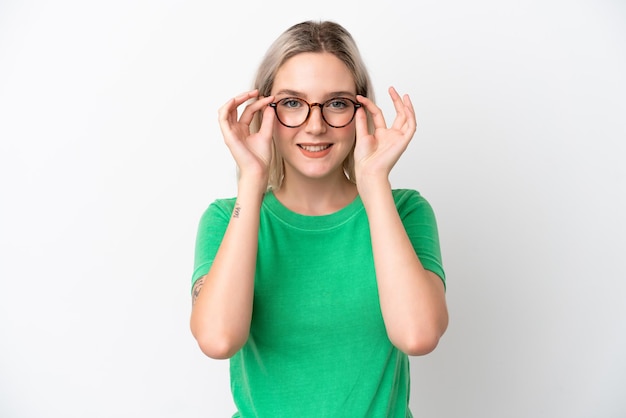 Jeune femme de race blanche isolée sur fond blanc avec des lunettes avec une expression heureuse