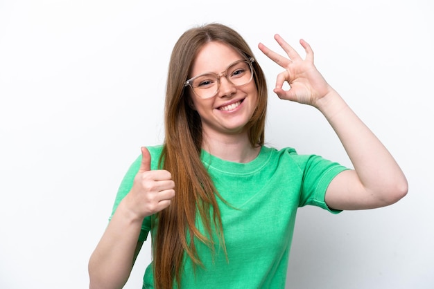 Jeune femme de race blanche isolée sur fond blanc avec des lunettes et faisant signe OK