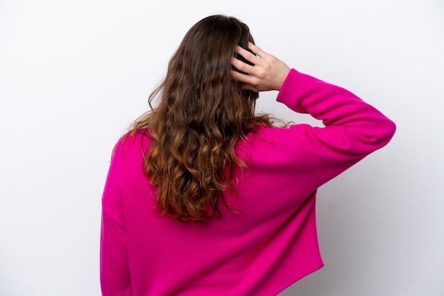 Jeune femme de race blanche isolée sur fond blanc en position arrière et pensant