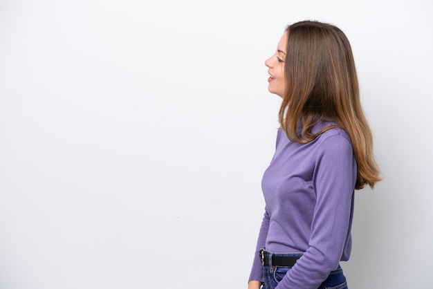 Jeune femme de race blanche isolée sur fond blanc en riant en position latérale