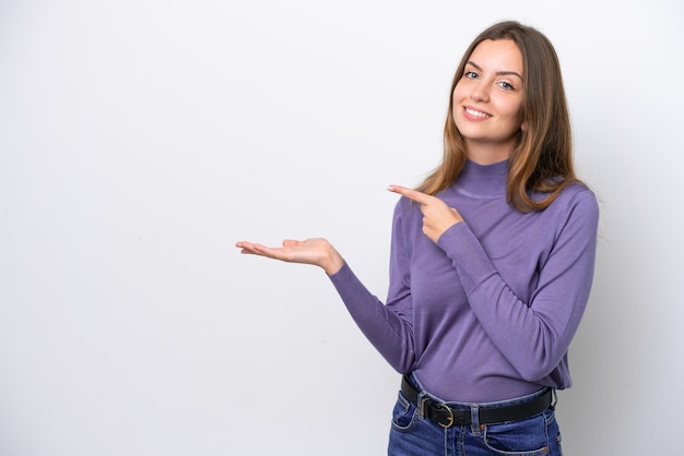 Jeune femme de race blanche isolée sur fond blanc tenant un espace de copie imaginaire sur la paume pour insérer une annonce