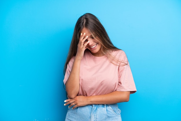 Jeune femme de race blanche isolée sur fond bleu en riant