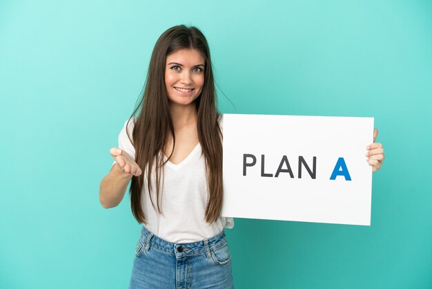 Jeune femme de race blanche isolée sur fond bleu tenant une pancarte avec le message PLAN A faire un accord