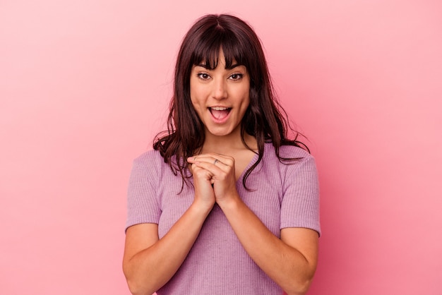 Jeune femme de race blanche isolée sur un mur rose priant pour la chance, étonné et ouvrant la bouche à l'avant