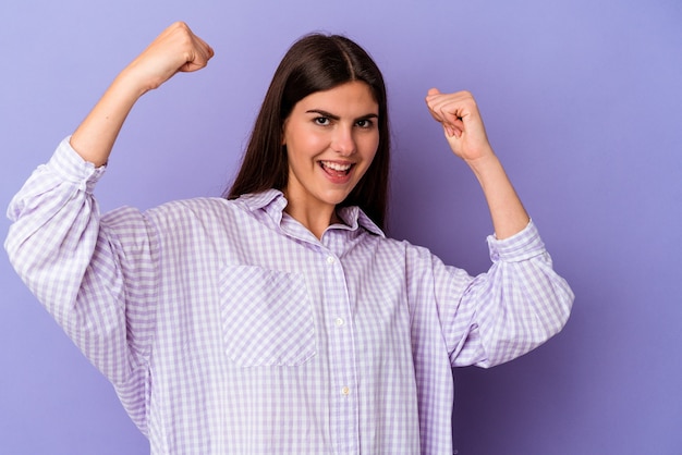 Jeune femme de race blanche isolée sur un mur violet applaudissant insouciant et excité